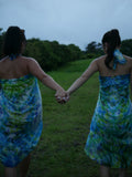 Models in green, blue, and navy shibori tie-dye silk wrap scarves, tied as pareo-style dresses, photographed at Olson Keolanui Farms in Hilo.
